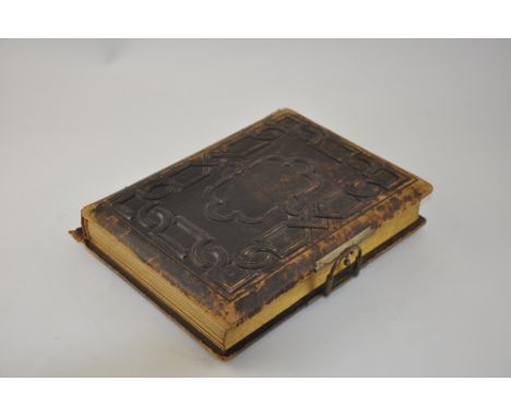 A late Victorian brown leather photograph album with geometric cover and floral print leaves containing monochrome portraits.