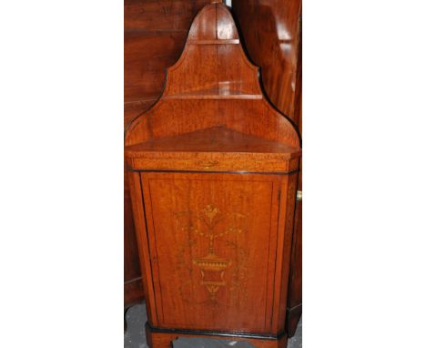 An Edwardian Sheraton Revival satinwood corner cabinet inlaid throughout with vases of flowers and scrolling foliage with rai