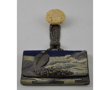 A Japanese Meiji period tobacco pouch embroidered with a sea eagle, white metal mounted with Mount Fuji thumbpiece, the ivory