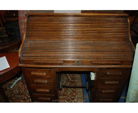 A ministry Oak Roll top Desk, having plain top over the tambour roller, opening to reveal various pigeon holes and drawers, t