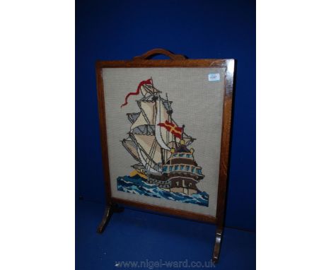 An Oak Firescreen with needlepoint picture depicting a galleon
