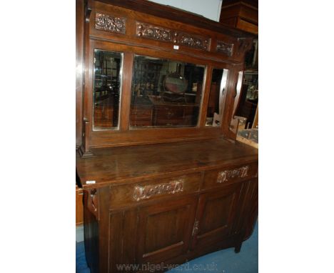 An elegant Arts and Crafts Oak mirrorback Sideboard with pierced gallery top over shelf, having three inset embossed copper p