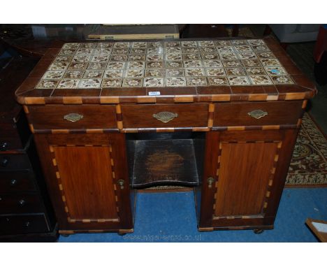 An unusual late 19th c. French Kneehole Desk, having floral tile top in cross-banded surround,  with multi-wood moulded edge,