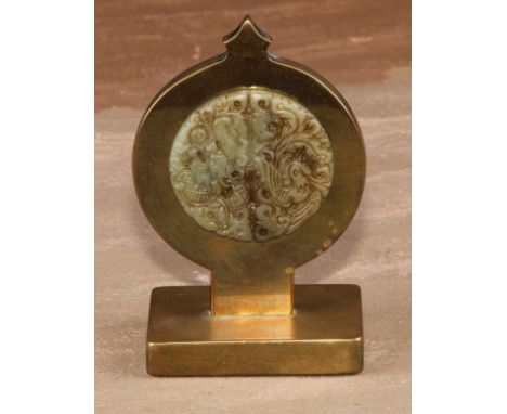 A 19th century brass pocket watch stand, incorporating a Chinese jade roundel, pierced and carved in the Archaic taste with a