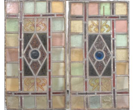 A pair of Arts &amp; Crafts period leaded stained glass rectangular panels, each with central bullseye panel within a diamond