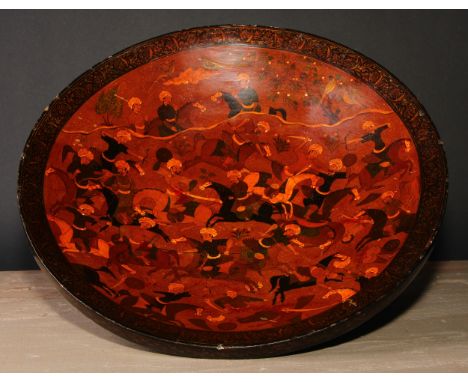 A Persian papier mache circular dish, profusely decorated in the Islamic Kashmiri taste with a hunting scene, 38cm diam 