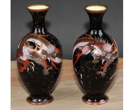 A pair of Chinese cloisonne enamel ovoid vases, decorated in polychrome with ferocious dragons, on a noir ground, 21cm high, 