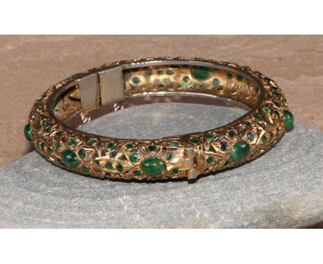 A gilt metal and green stone hinged bangle, possibly Indian, 8cm 