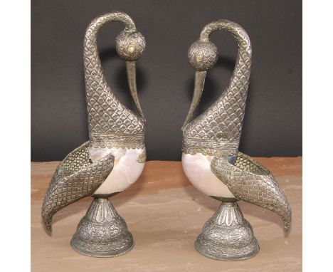 A pair of Tibetan/Nepalese silver coloured metal mounted pearl nautilus shell models, of birds, chased with stylkised lotus, 
