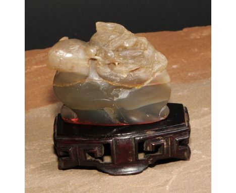 A Chinese hardstone seal, carved with a dragon, 6.5cm wide, hardwood stand 