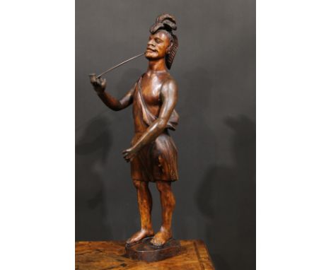 A 19th century carved tobacconists advertising figure as a native American, standing wearing feathered headdress and smoking 