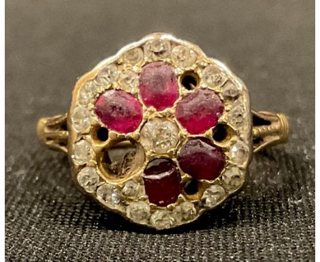 An 18ct gold flower head diamond and ruby cluster ring, size L/M, some stones lacking, 4.4g 