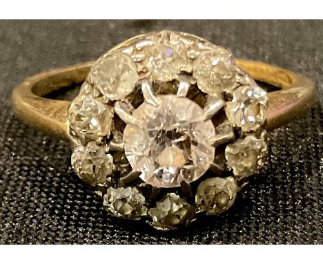 An 18ct gold diamond flower head cluster ring, the central brilliant cut stone surrounded by ten smaller old cut stones, size