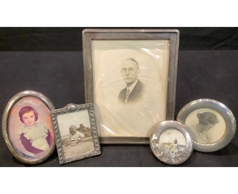 A rectangular silver photograph frame, Birmingham 1926, 24cm x 18.5cm; a circular silver photograph frame, 11.5cm diameter, B