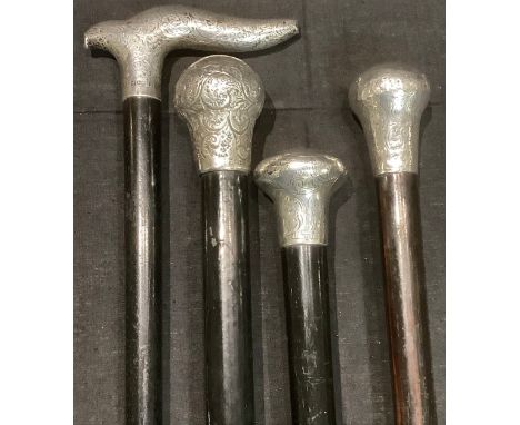 Walking Sticks - an ebonised walking cane with silver pommel, Birmingham 1919; others similar, all hallmarked silver (4) 