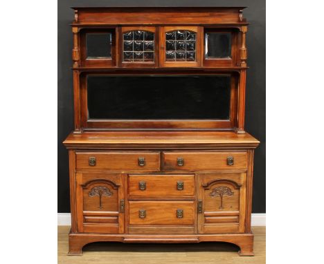 An Arts &amp; Crafts period walnut sideboard, the shaped superstructure with a pair of lead-glazed bubble-glass doors and bev