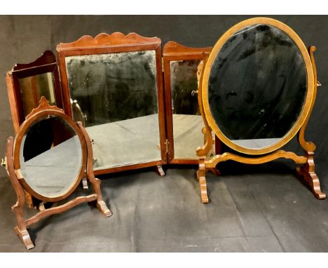 An early 20th century oval mahogany dressing mirror, 43.5cm; another small;  a tryptic mirror (3) 