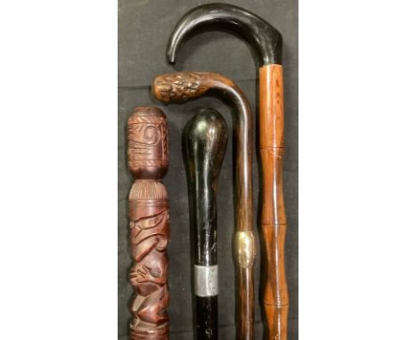 Walking Sticks - a silver mounted ebonised walking stick; a carved walking stick; a yellow metal mounted stick, etc (4) 