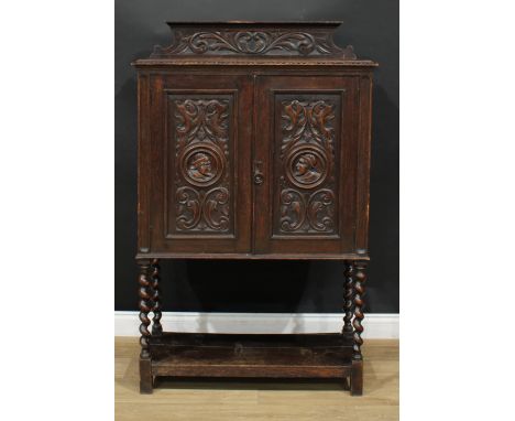 A 17th century style oak livery cupboard or side cabinet, rectangular top with shaped half-gallery carved with acanthus, abov