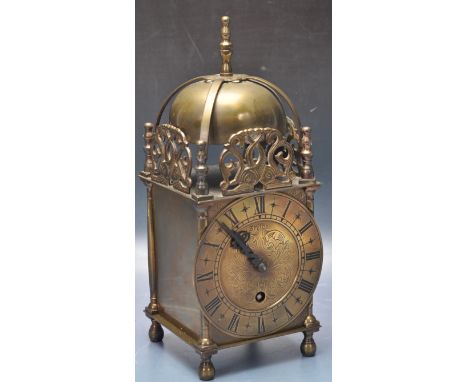 A 20th century brass lantern clock by Smiths. The clock having a brass body with Roman numerals to the chapter ring, circular