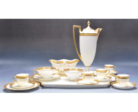 An early 20th century Minton &amp; Limoges trayed cabaret ceramic tea service having an armorial crest with fine gilding work