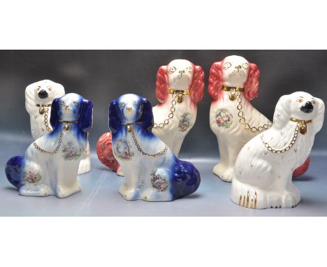 A collection of early 20th Staffordshire spaniel figures to include a pair of white Royal Doulton dogs and two pairs of K.M P