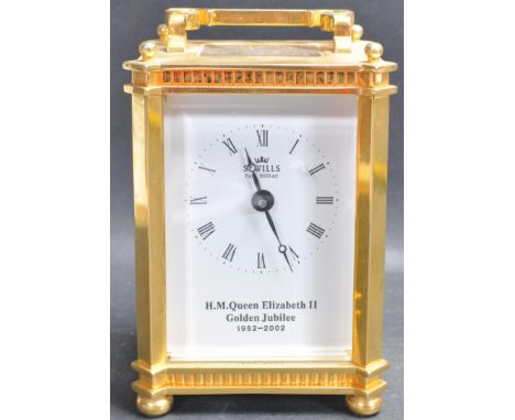 A 21st century brass cased carriage clock upon ball feet with swing handle atop. The face having roman numeral to the chapter