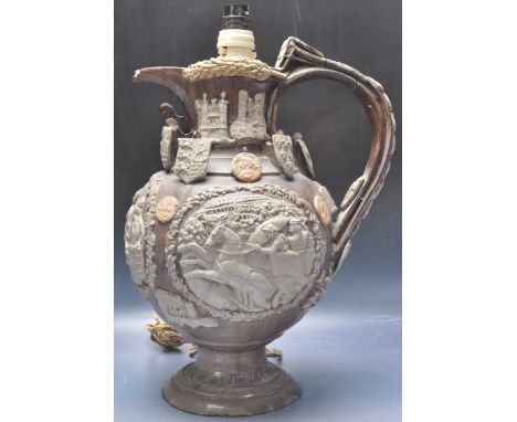 A Castle Hedingham pottery 'The Essex Jug'. A 19th century Victorian ceramic porcelain jug, on a brown ground with three rais