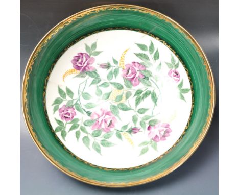A vintage 20th century ceramic bowl having a green border with polychrome floral decoration to the centre and gilt detailing 