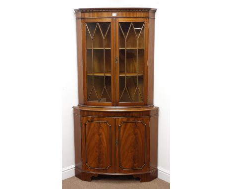 Reproduction mahogany double bow front corner cabinet, projecting cornice, dentil frieze, two glazed doors enclosing two shel