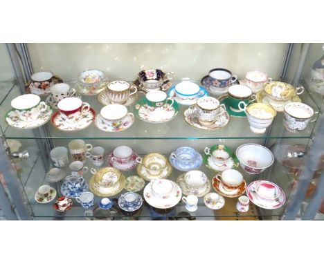 The contents of two shelves: a collection of mostly 19thC. & antique porcelain cups & saucers including Spode, Foley & Limoge