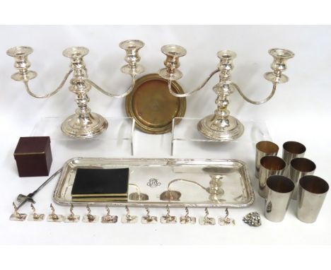 A pair of silver plate on copper candelabra, a plated drinks stand, six graduated plated cups with internal gilding, a set of