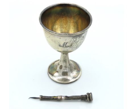 A 1917 Sheffield silver egg cup by Aitkin Bros. monogrammed "M" twinned with an a/f 1896 Victorian silver cigar piercer, 45.8