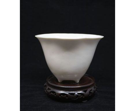 A large Dehua Qing Dynasty Blanc de Chine Libation Cup in the form of a Lotus flower, raised on three vestigial feet. The ext