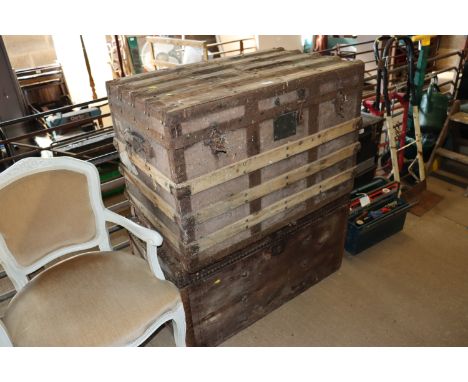 A canvas and wooden and metal bound travelling trunk and a wooden storage trunk