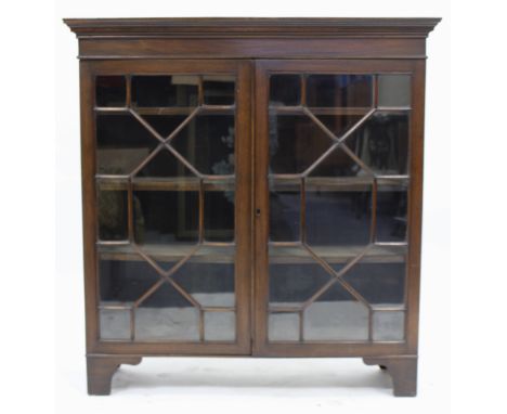 A MAHOGANY BOOKCASE with astragal glazed doors enclosing shelves within and standing on bracket feet, 112cm wide x 118cm high
