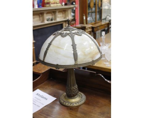 A GILT CAST METAL ART NOUVEAU STYLE TABLE LAMP with semi spherical glazed shade, fluted and acanthus leaf decorated column su