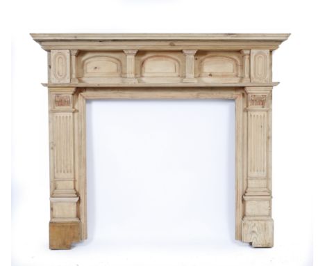 AN EDWARDIAN PINE FIRE SURROUND, the mantle shelf with further shelf below with carved supports and fluted pilasters to eithe