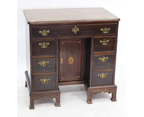 A GEORGIAN AND LATER MAHOGANY KNEE HOLE DESK with inlaid decoration to the top and seven drawers around a central knee hole w