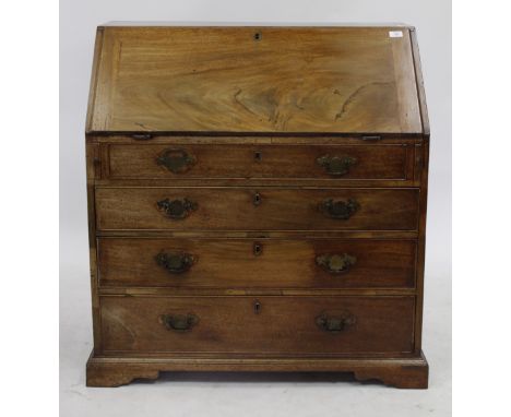 A GEORGE III MAHOGANY BUREAU, the fall front enclosing a fitted interior over four long drawers and standing on bracket feet,