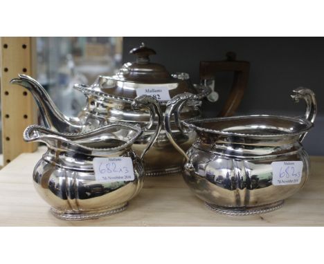 AN ANTIQUE THREE PIECE SILVER PLATED TEASET with gadrooned edge to the teapot, sugar basin and milk jug