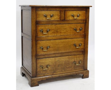 A REPRODUCTION OAK CHEST OF TWO SHORT AND THREE LONG DRAWERS with brass swan neck handles and raised on bracket feet, 76cm wi
