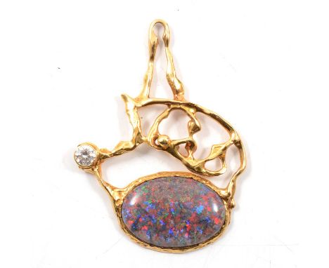 A yellow metal pendant set with an oval cabochon cut treated opal, the 32x22mm opal set in a yellow metal contemporary abstra