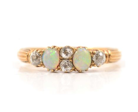 An opal and diamond half hoop ring, two 4mm oval cabochon cut opals and four old cut diamonds claw set in an all yellow gold 