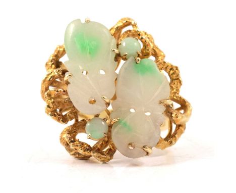 A large two tone jade dress ring marked 585, two carved jade pieces each 17x9mm and two small jade cabochons, claw set in a m