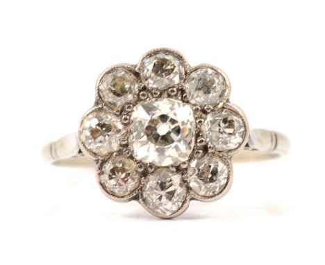 A nine stone diamond cluster ring, the old brilliant cut stones pip claw and millegrain set in an all white metal 12.5mm circ