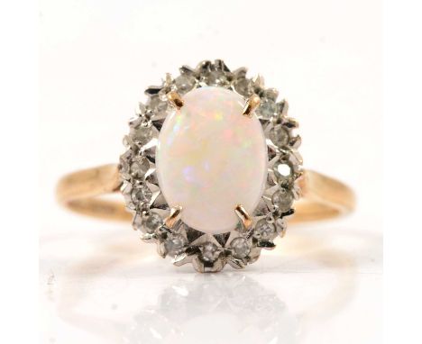 An opal and diamond oval cluster ring, the oval cabochon cut opal 9x6mm, four claw set and surrounded by eighteen 8 cut diamo