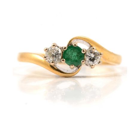 An emerald and diamond three stone ring, the round faceted emerald and pair of brilliant cut diamonds claw set in an 18 carat