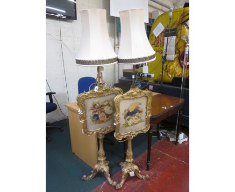 A pair of giltwood polescreens 19th Century and later now with light fittings each with needlework panel on tripod base 135cm