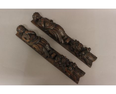 A PAIR OF OAK CARYATIDS, late 17th or early 18th century, carved with figures holding tools above floral sprays, height 51cm 